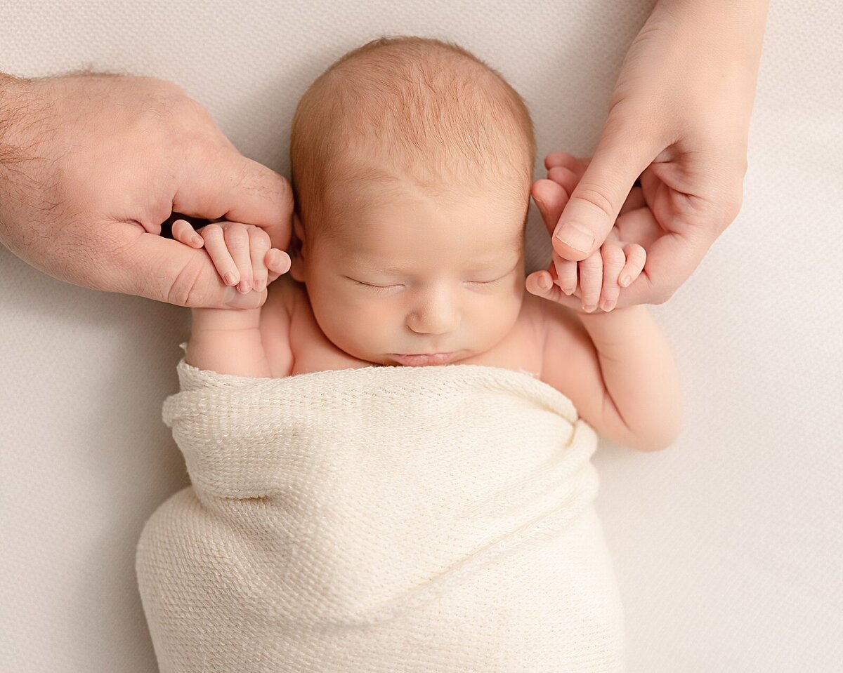 baby girl with parents hands