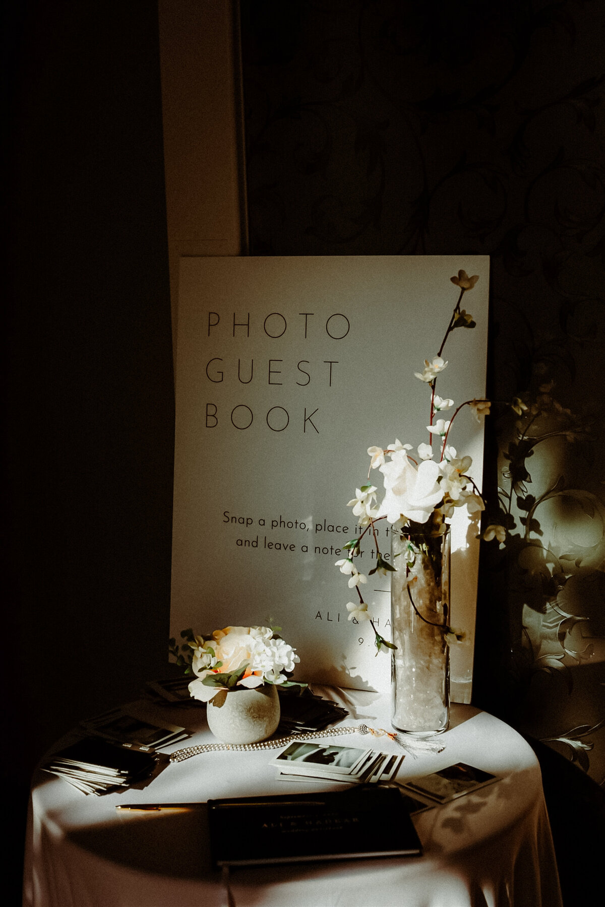 detail image of a wedding sign with florals in a ray of natural light