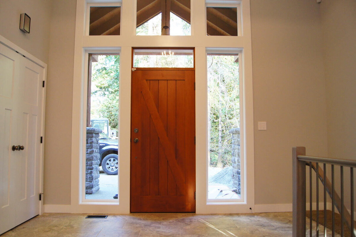 Craftsman style home entry with custom wood entry door and sidelights.