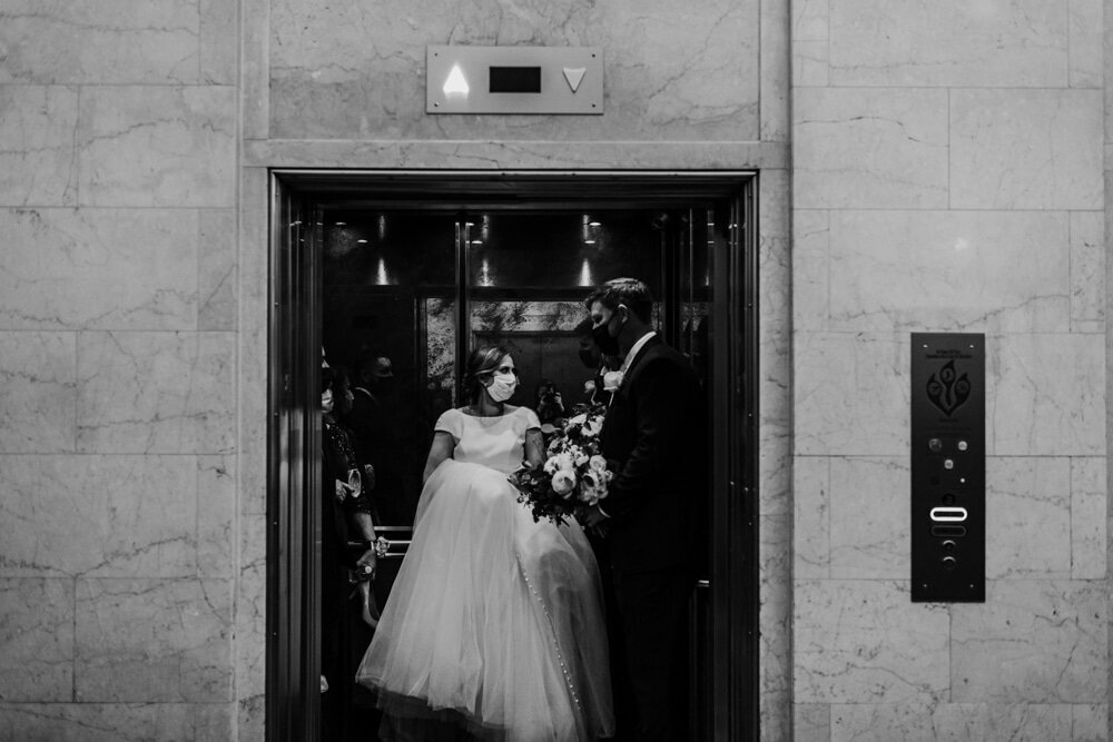 Maryland wedding photographer captures elevator wedding pictures with bride and groom exiting an elevator at their luxury Baltimore wedding venue