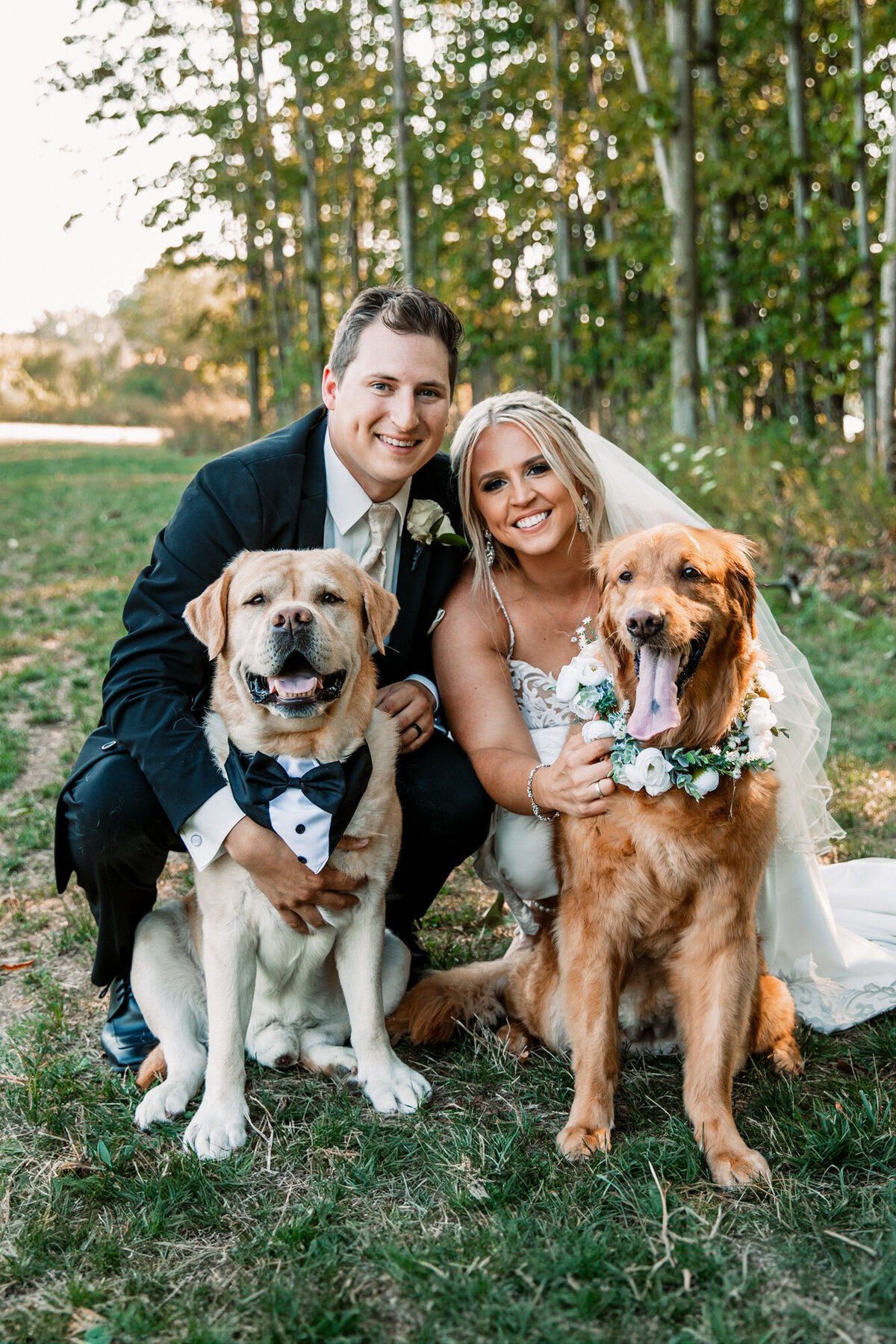 bride and groom smile with dogs at the camera