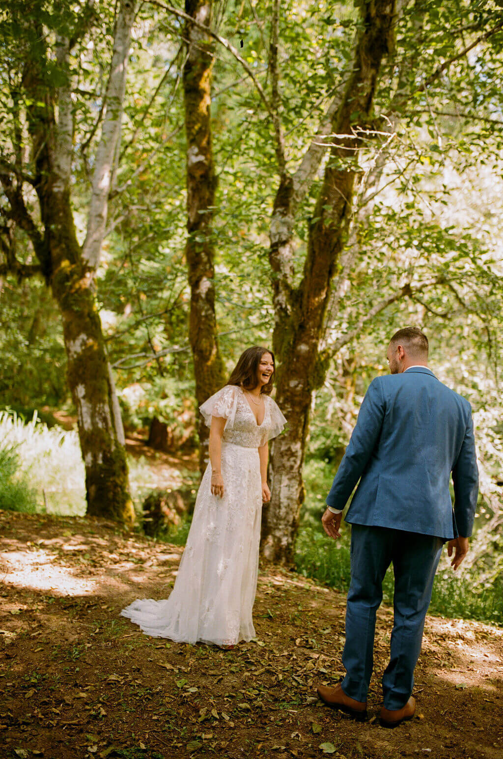 Bride and groom smile during first looks before their outdoor Oregon wedding.