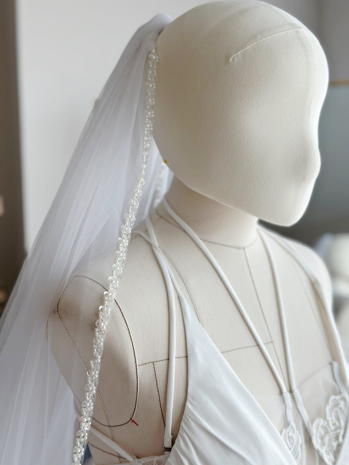 Bride wearing soft single-tier veil with delicate beaded edge
