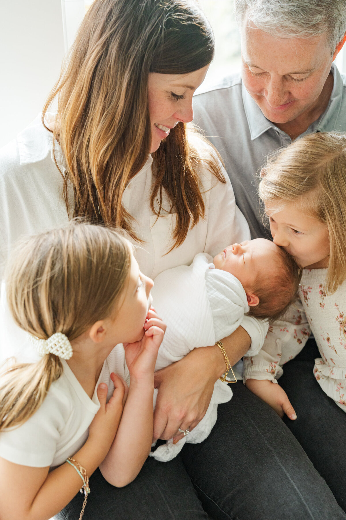 A close-up of a family embracing their newest member, surrounded by love and warmth as they cherish the moment