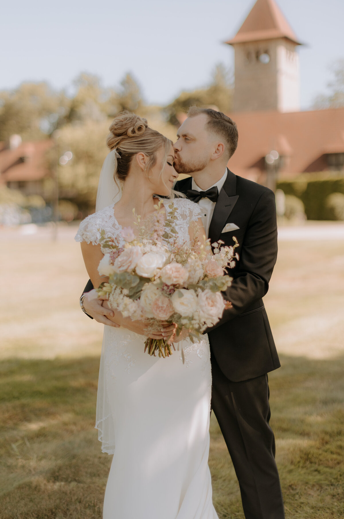 groom-kissing-bride-on-forhead-portrait-saint-clements-castle