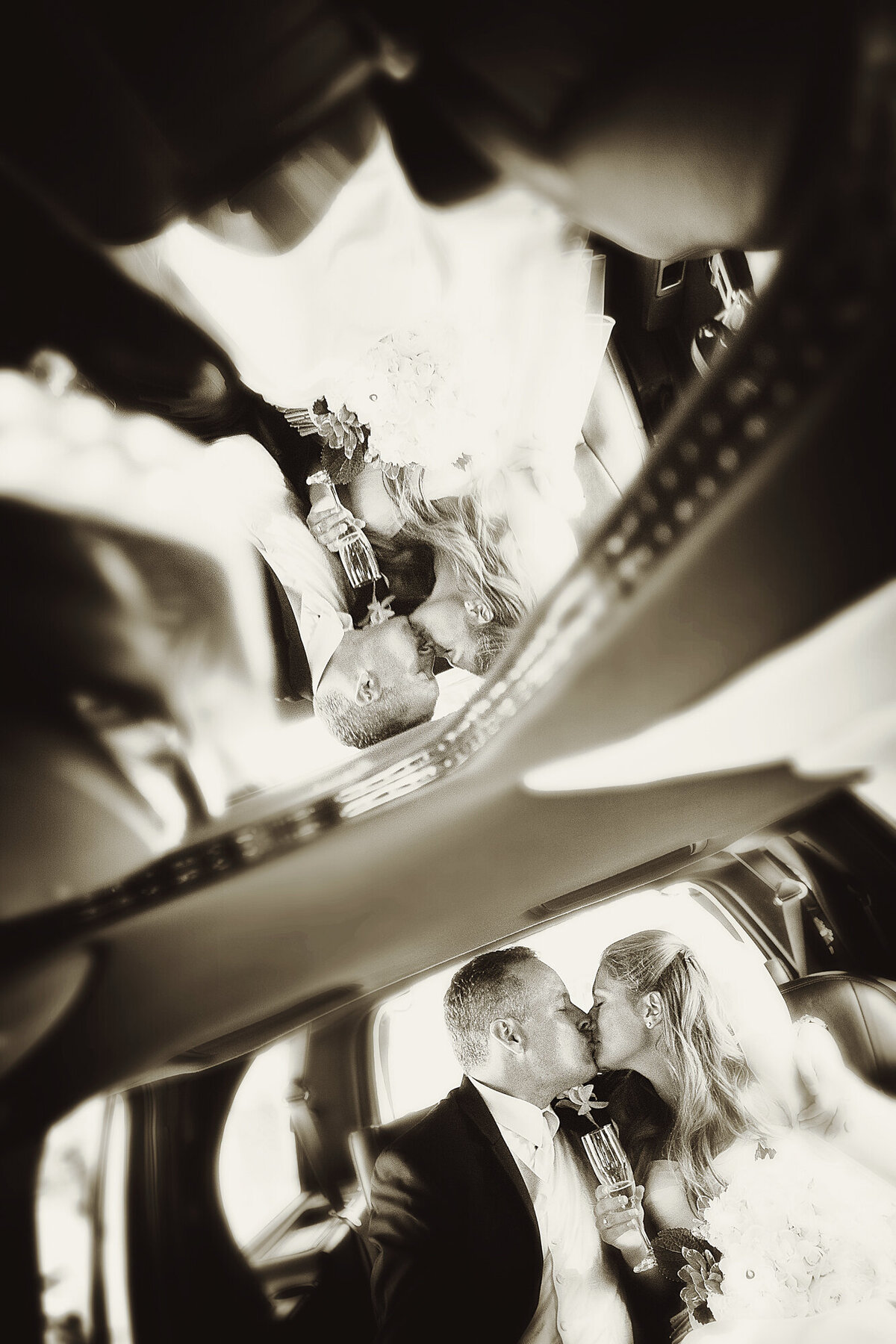 An artistic shot of a bride and groom kissing inside a limo.