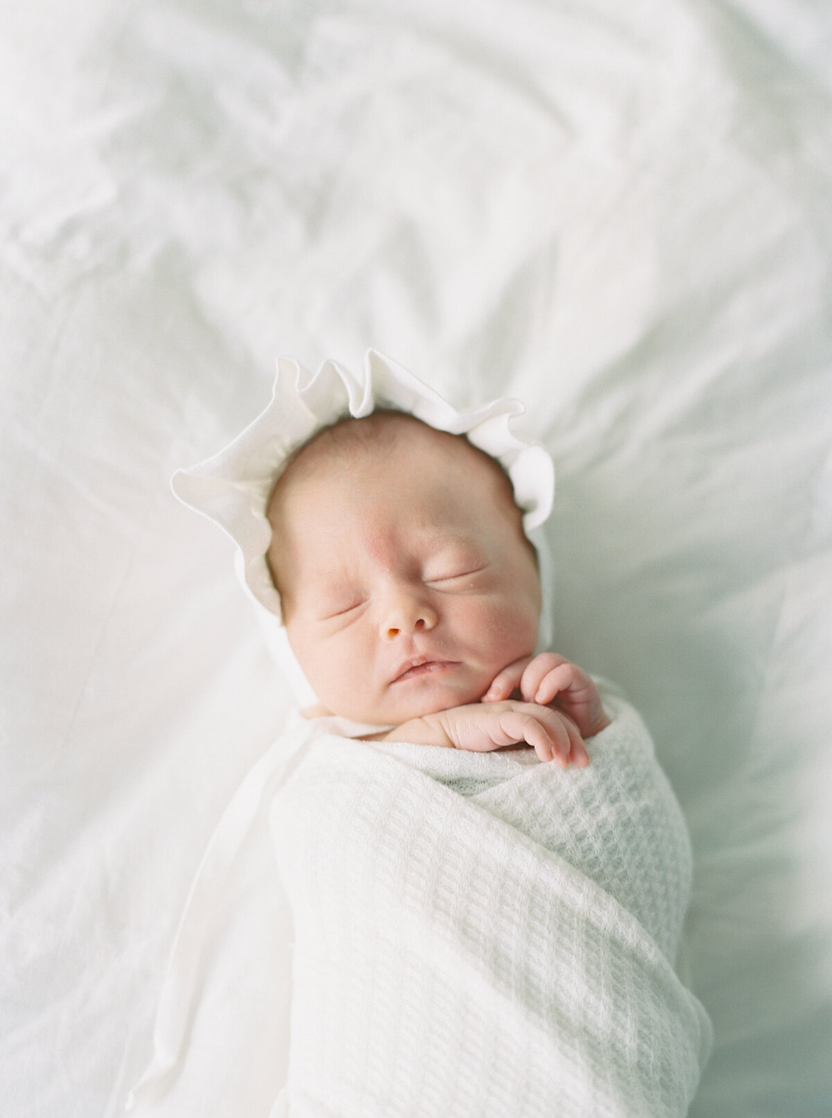 newborn baby girl in all white by photographer in madison wi talia laird photography