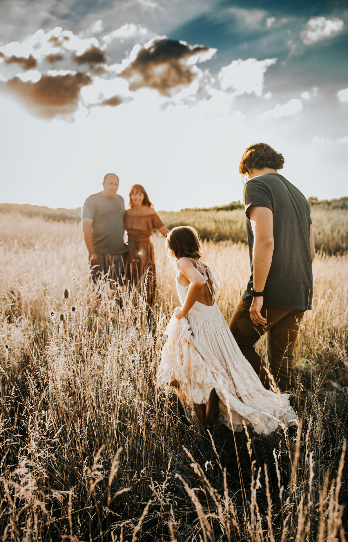 siblings walking toward parents, sunset behind subject , they are walking on the field White Sands New Mexico