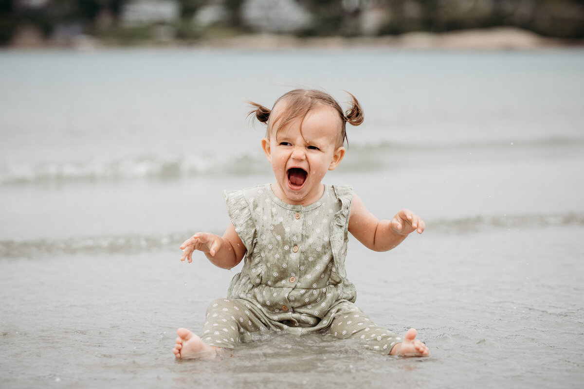 photoshoot where baby is in the water laughing and smiling