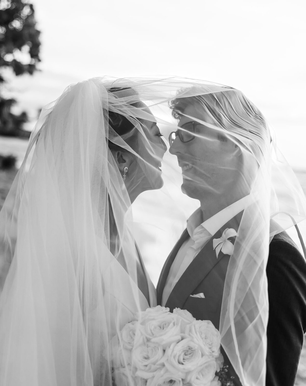 black and white nostalgic bride and groom under veil