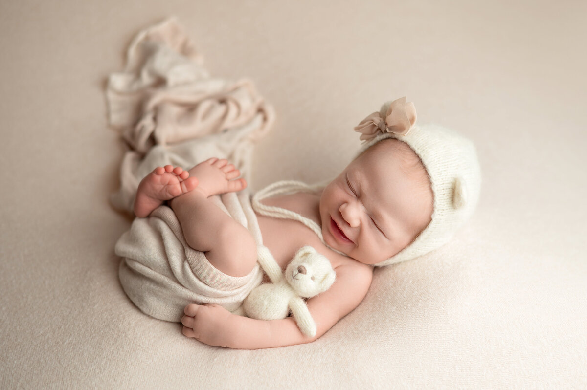Baby girl posed with soft pastel props and accessories – newborn photography Houston