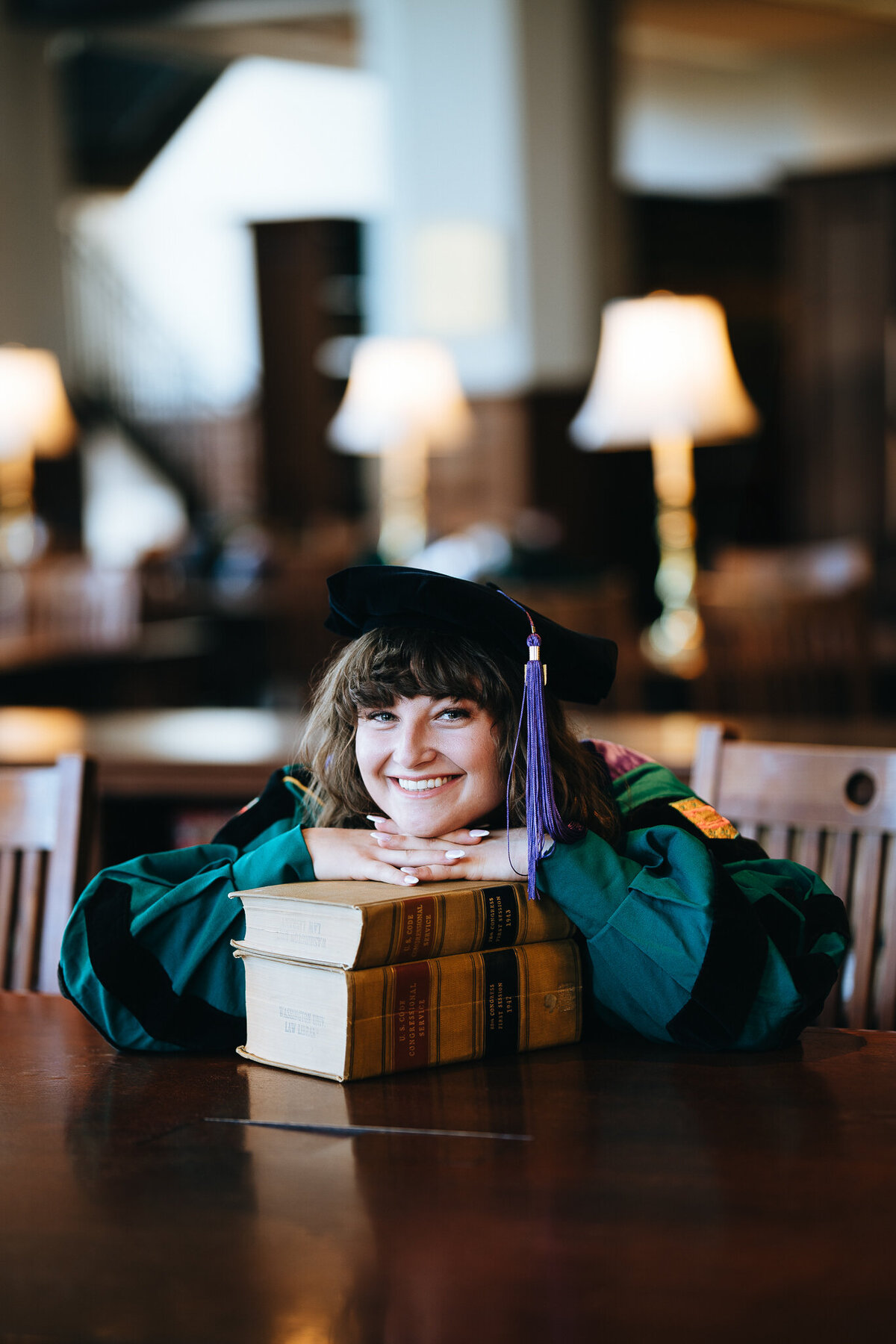 washu law grad resting on stack of law books at washu law library