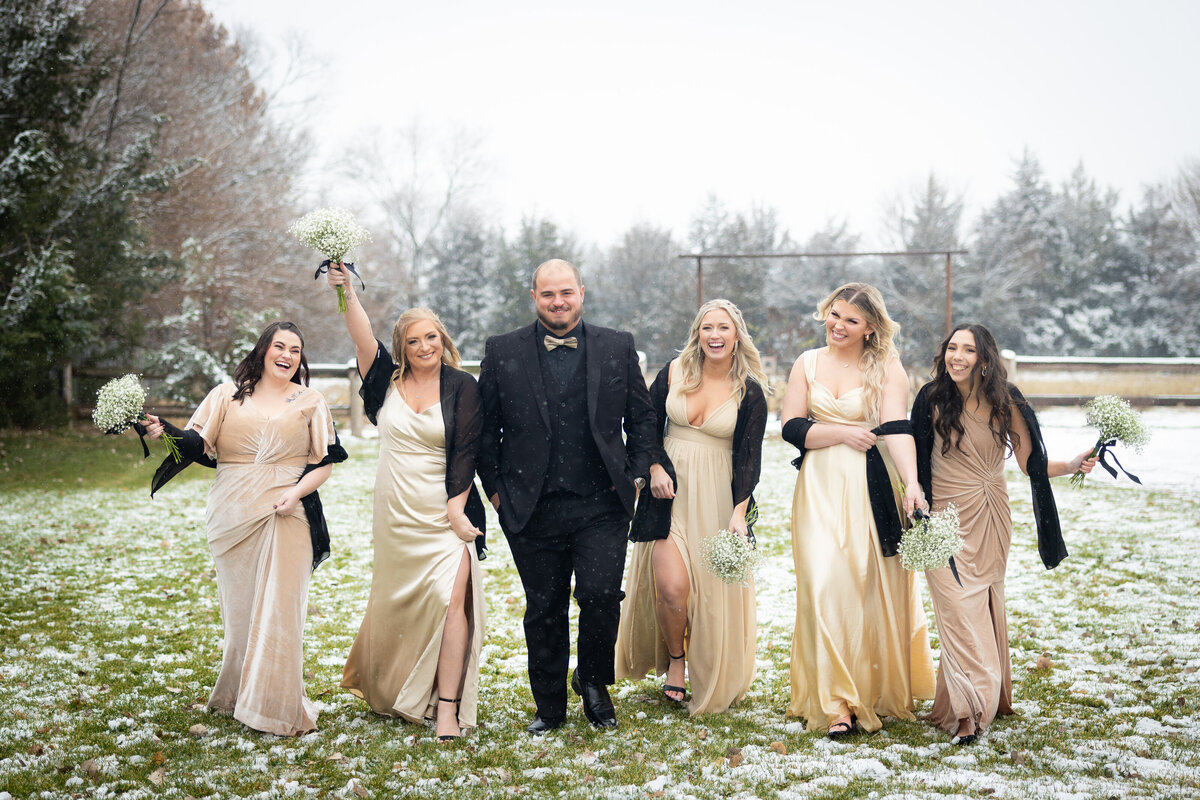 groom with bridesmaids walking and celebrating