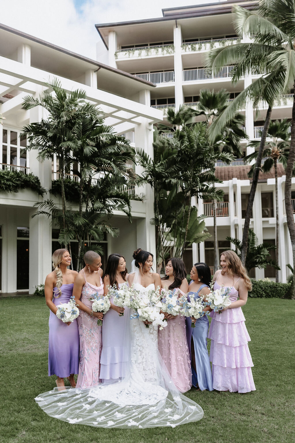 bride with bridesmaids in multicolor hues of blue and purple dresses at four seasons Oahu