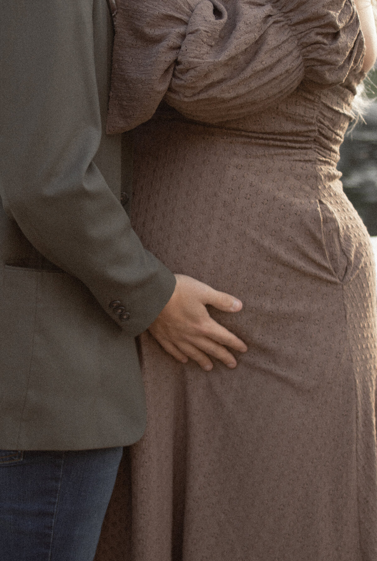 close up of husband's hand of expecting mom's belly