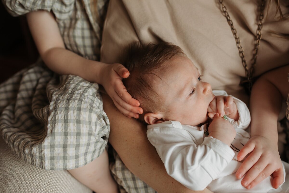 close up of a baby being held by his mother