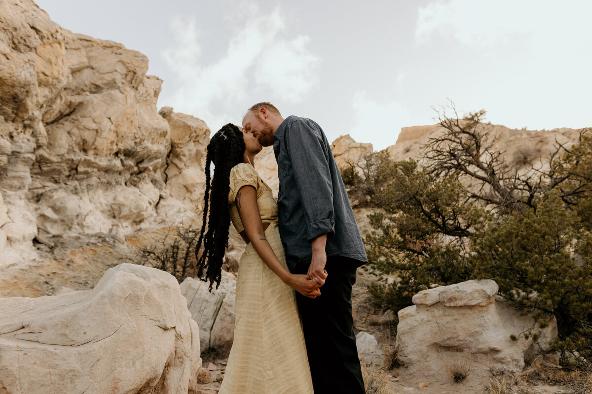 man and woman kissing in the desert
