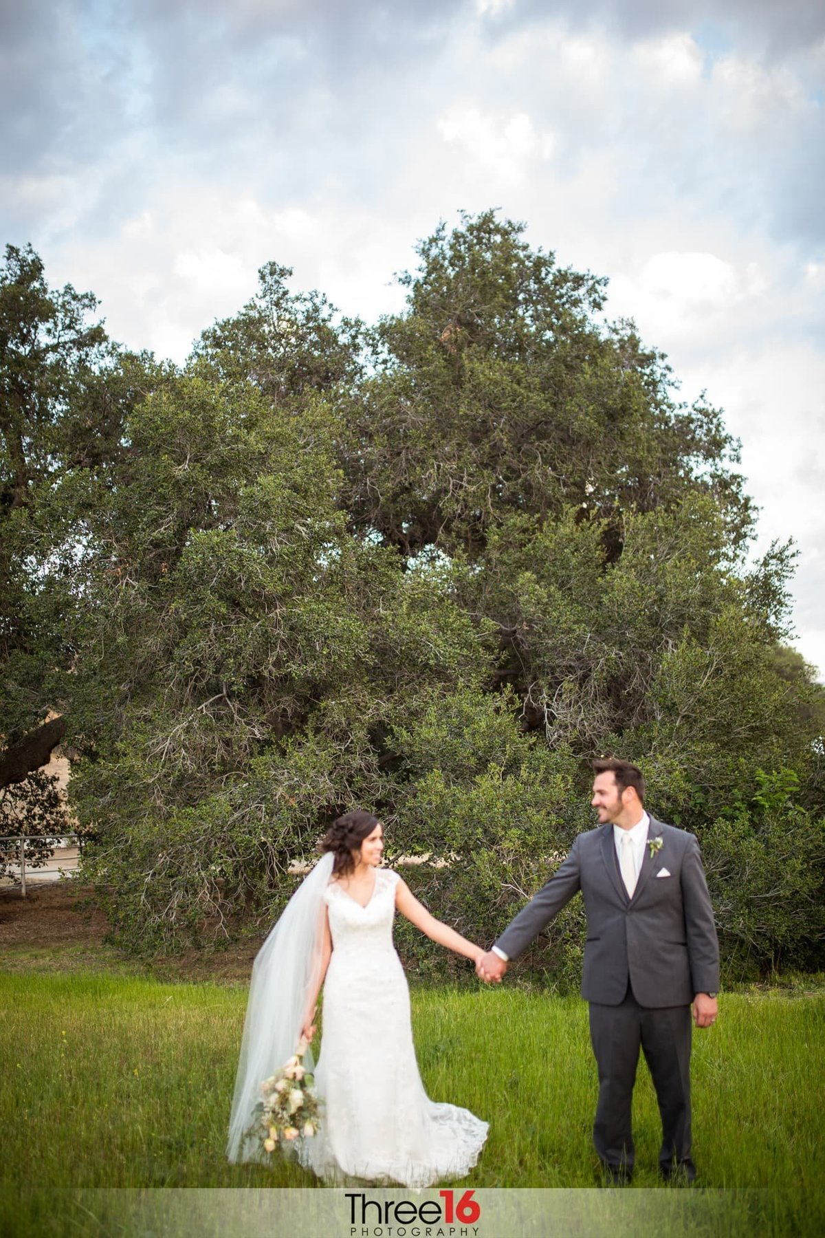 Bride and Groom holding hands in a field at Hold Out Ranch