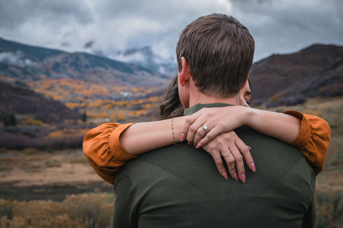 Close portrait of an engaged couple sharing a kiss in the mountains