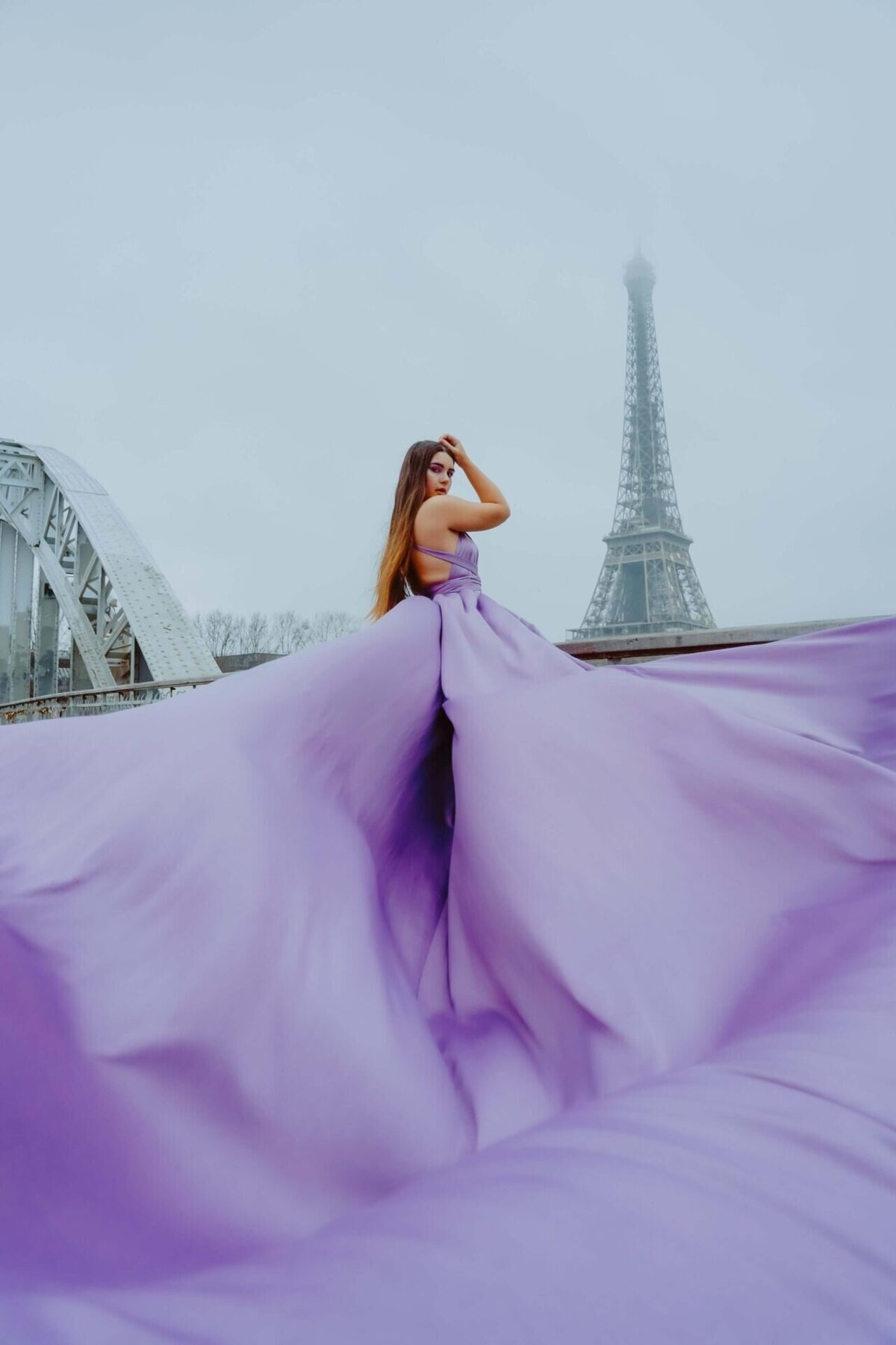 women having a portrait photoshoot in paris wearing a purple flying dress