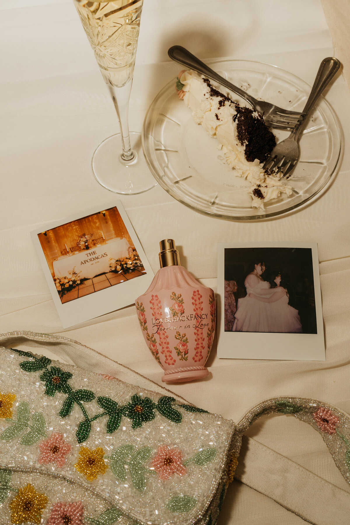 Polaroids laid on a table next to a bottle of perfume 