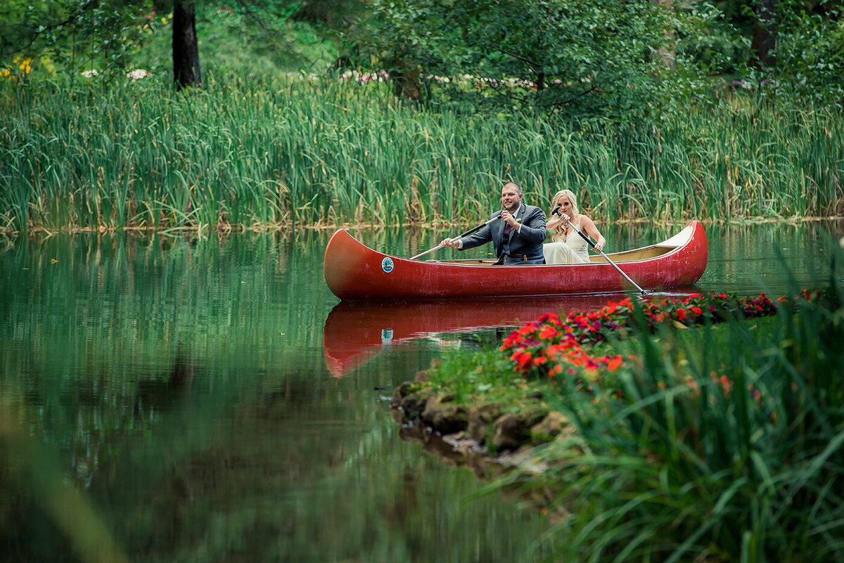 bride and groom smiling in canoe