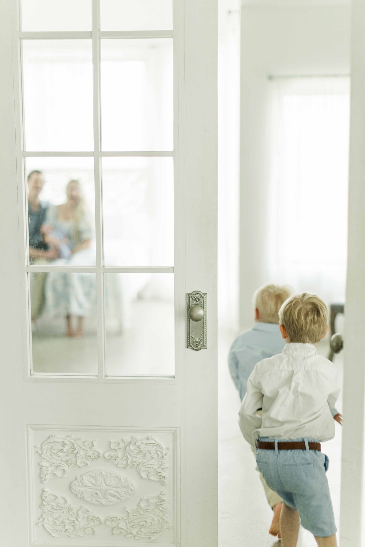 boys run into see baby brother in newborn session