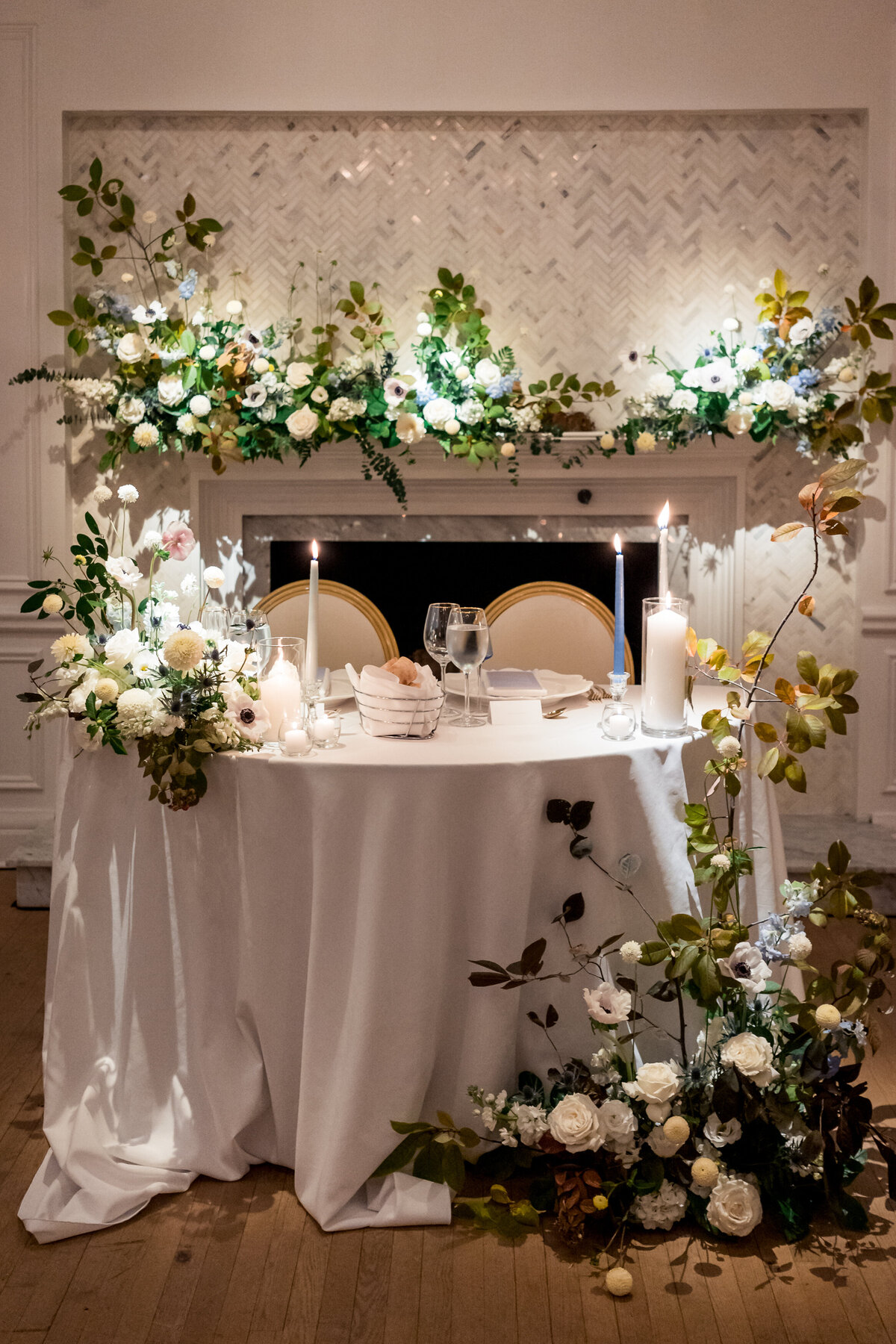 Lush sweetheart flowers on a table and fireplace at an Atwater Club wedding reception.