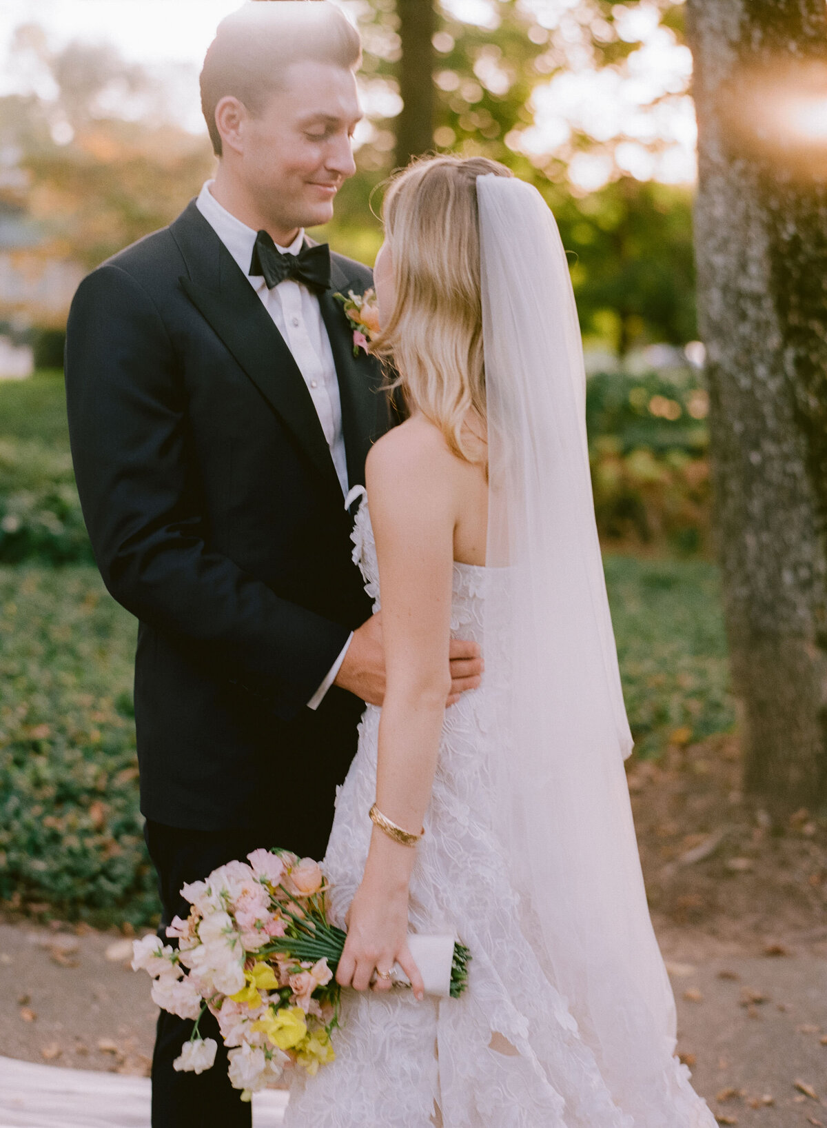 Product clustered bridal bouquet with sweet peas, local zinnias, and butterfly ranunculus. Elegant and simple bridal bouquet and bridal party bouquets with hues of blush and pops of yellow. Unique fall wedding design for private residence wedding in Nashville, TN. Bridal party wearing brown and wedding design with touches of brown. Design by Rosemary & Finch Floral Design in Nashville, TN.