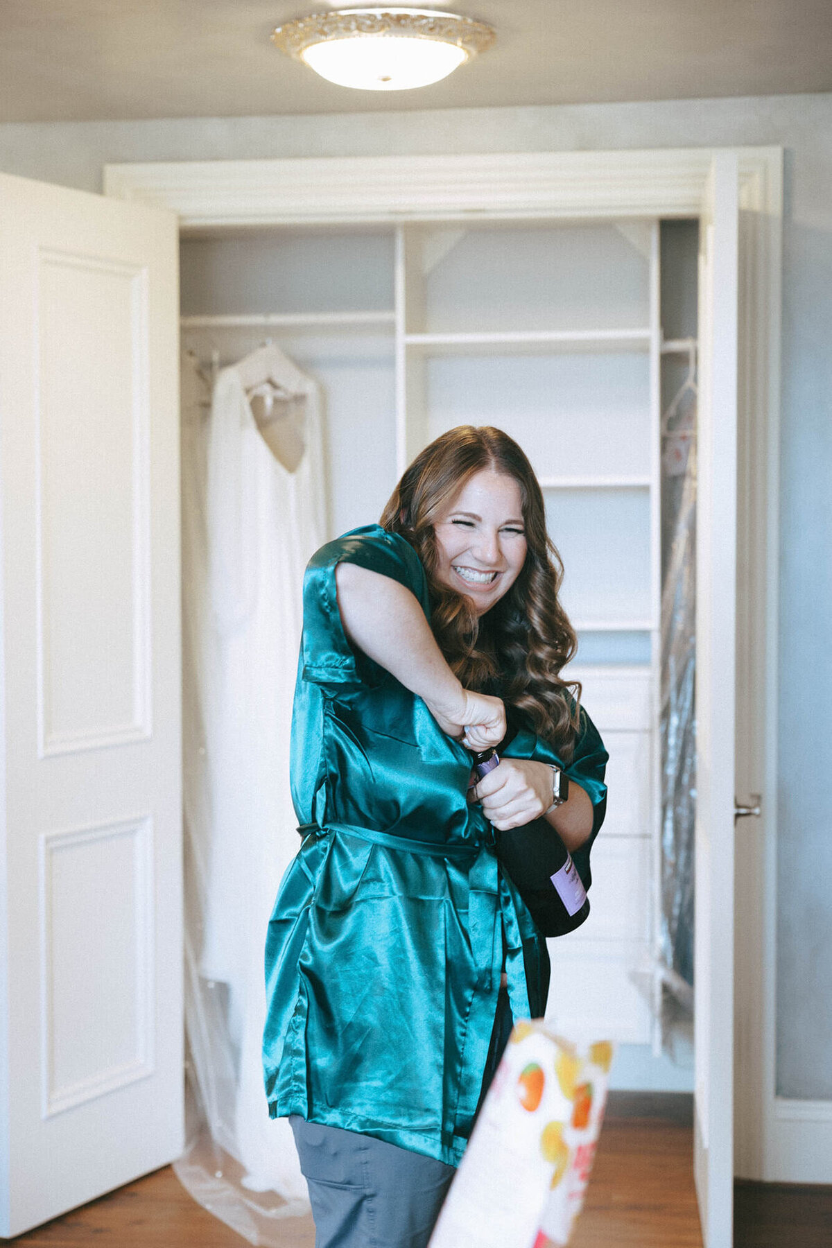 Bridal party member popping champagne, representing the fun and enjoyment everyone enjoys when you hire a wedding planner. 