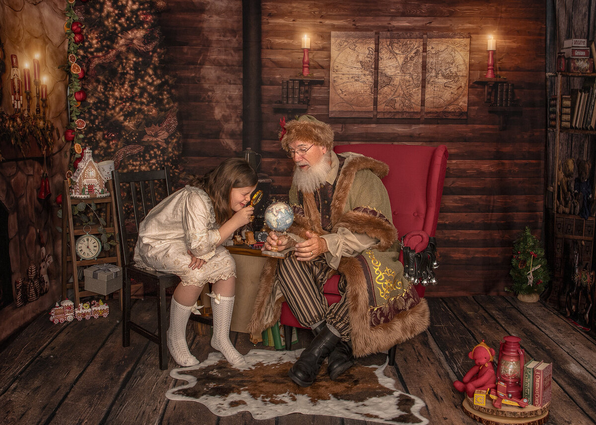 A magical moment as Santa shows a child his Christmas Eve flight path on a glowing globe, framed by cozy holiday décor.