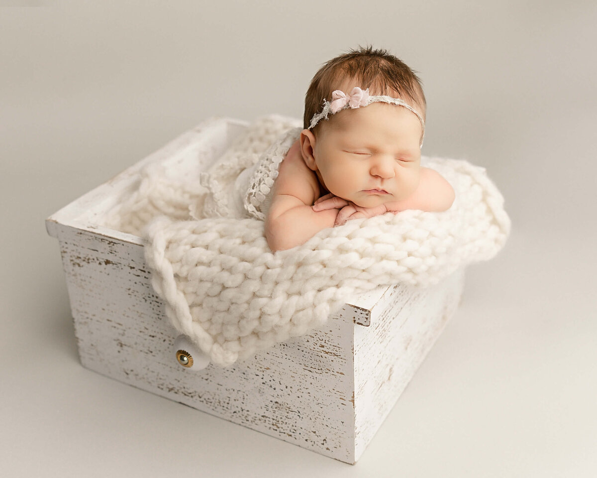 baby girl with white headband on sleeping in drawer