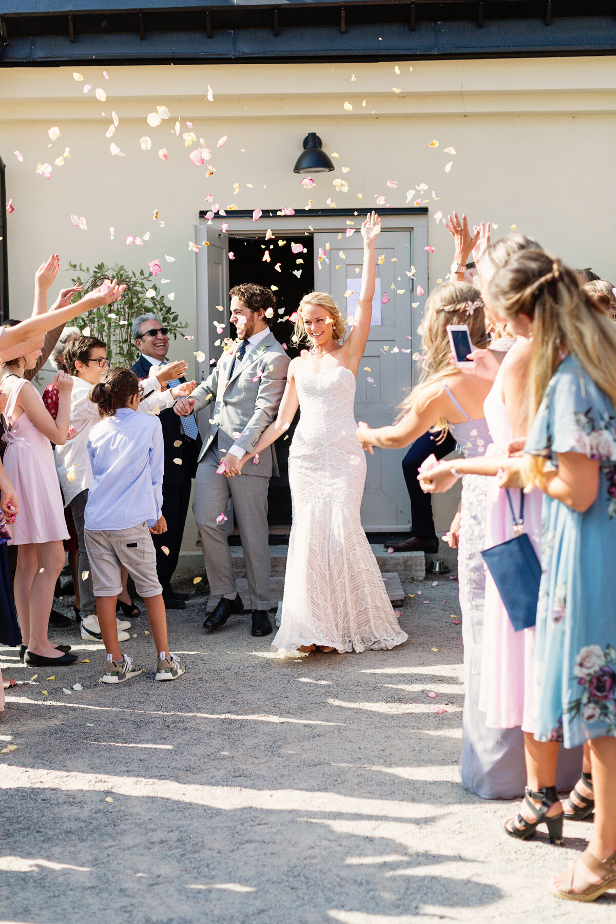 Bröllopsgäster kastar konfetti och blommor på brudparet på Fredriksborgs Hotell på Värmdö
