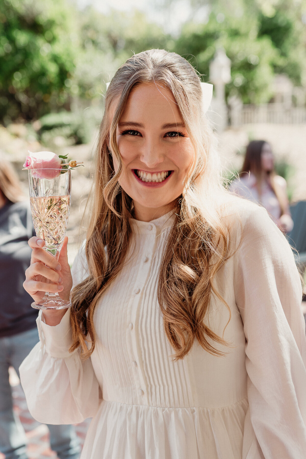 happy bride to be holding a glass of champagne with a rose