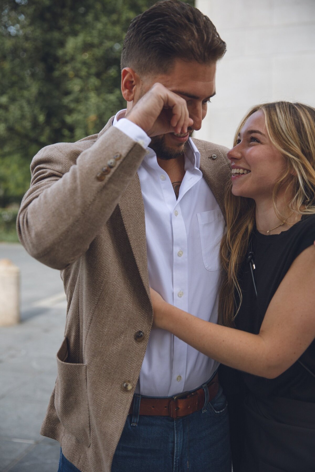 Emotional post-proposal hug between bride-to-be and groom.