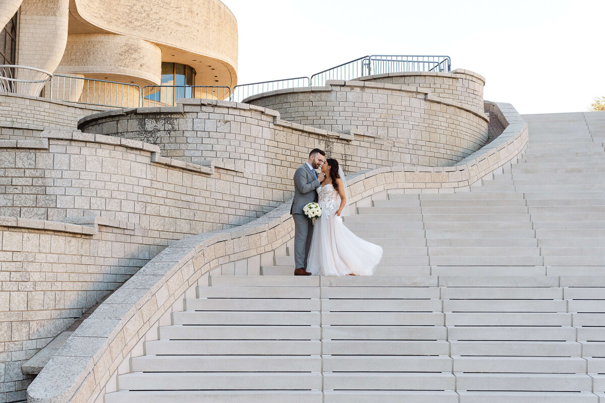 Ottawa wedding photography showing a bride and groom kissing on the steps of the Museum of History venue