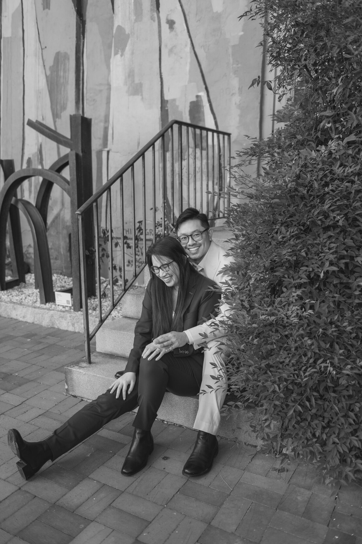 A couple sits on a staircase outdoors
