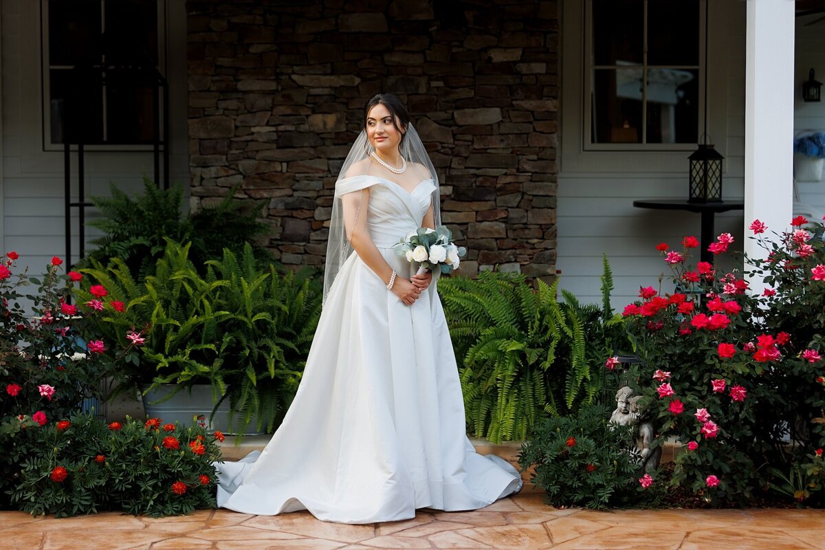 bride in a white wedding dress holding a bouquet of white flowers