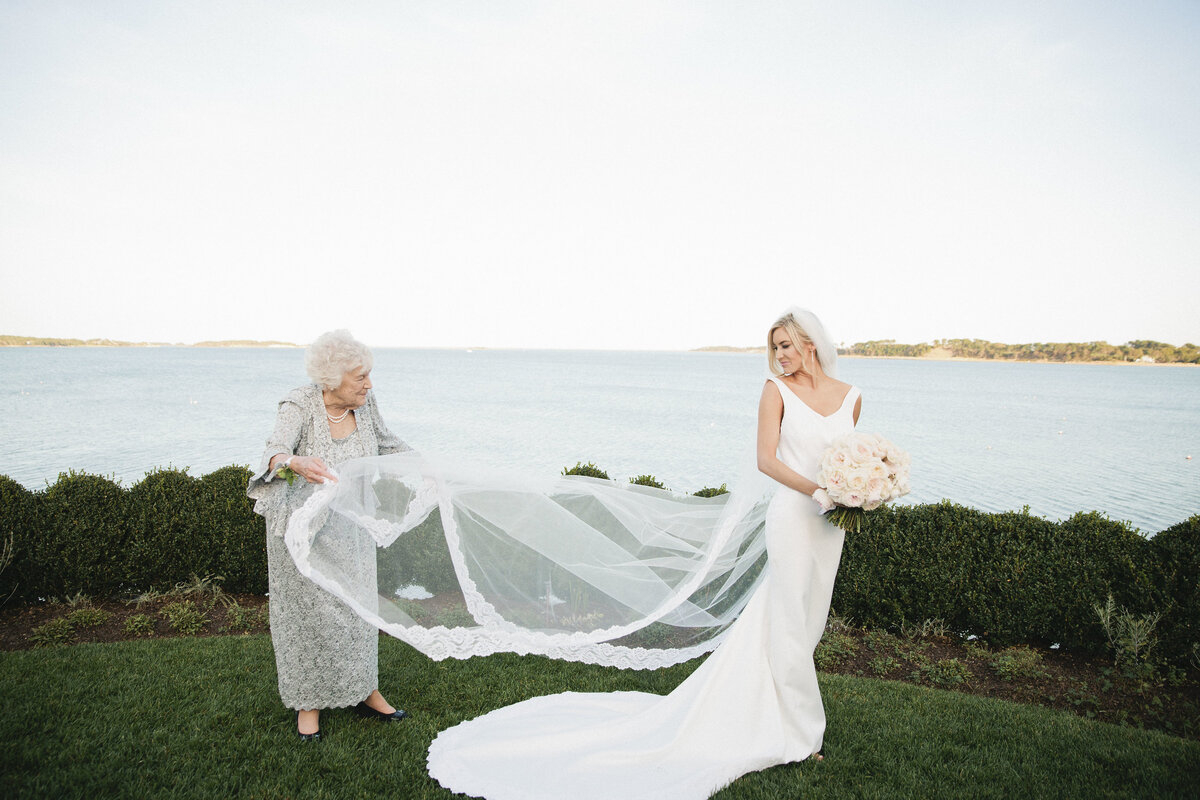 Whitney BIschoff's grandmother fluffing the bride's dress and holding the bride's train
