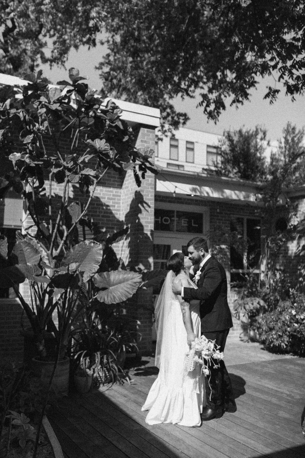 Bride and groom kissing outside the Carpenter Hotel