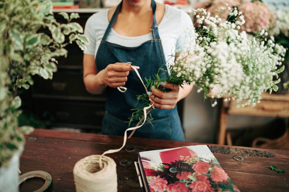 woman-s-hand-tying-bunch-flowers-with-string-shop (1)