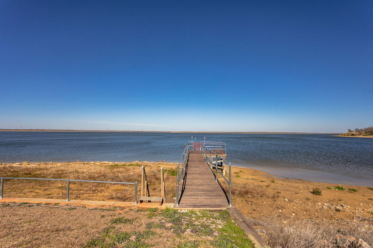 Lakefront view with dock access at this 2-bedroom, 2-bathroom lakeside vacation rental home for 6 guests on Tradinghouse Lake with privacy access to a fishing dock and boat launch pad, ping pong table, gazebo, free wifi and free parking in Waco, TX.