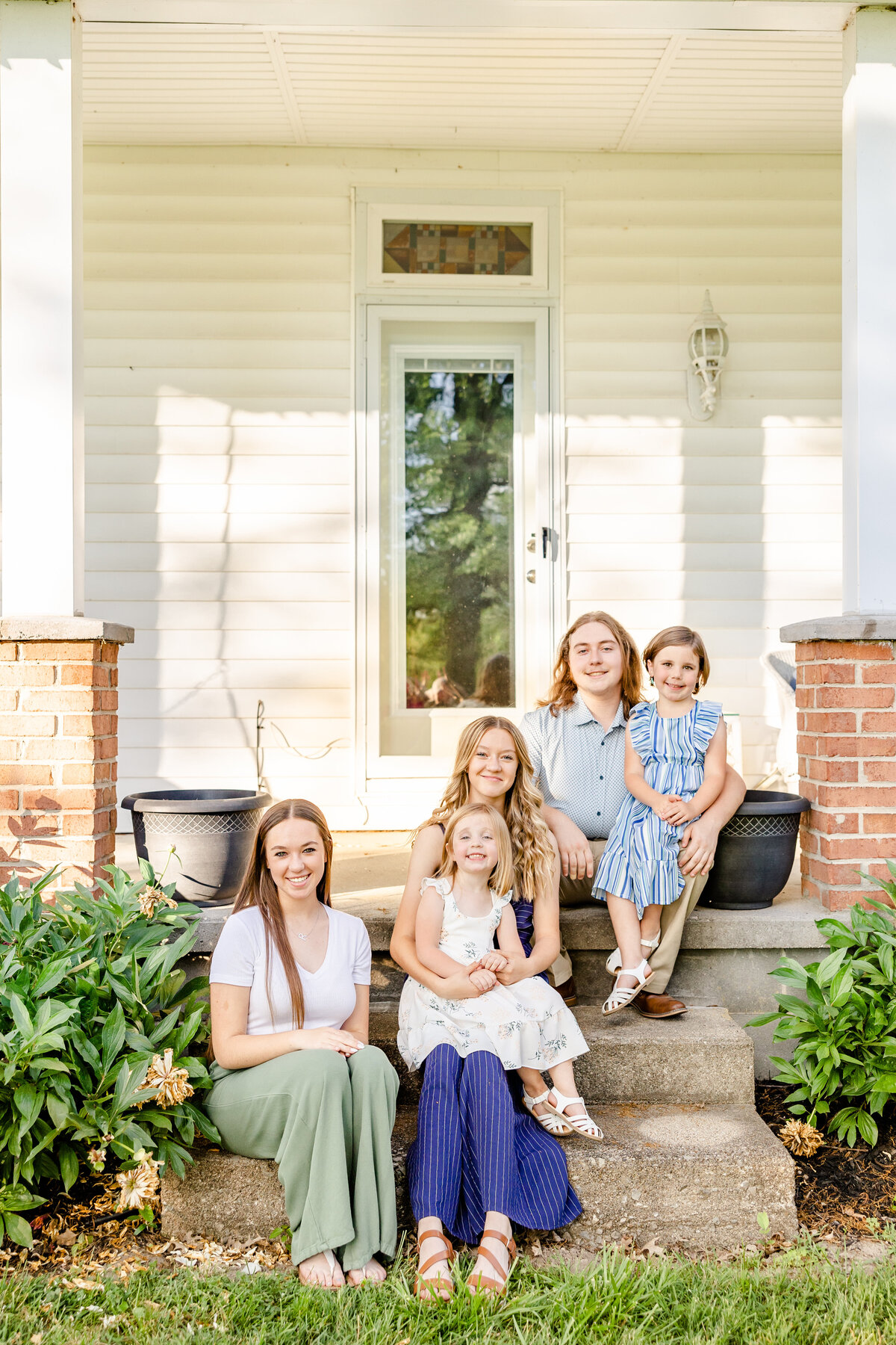 Cousins and siblings sitting on the front porch steps and grandma and grandpas house in Sardinia, Ohio.