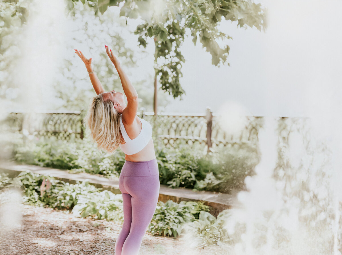 Brand portrait of Amy Witte taken in a serene, leafy setting in St. Paul for Inhale/Exhale Yoga.