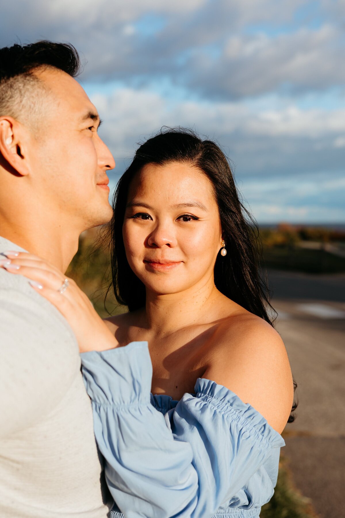 couple taking portraits with the husband looking away and wife looking towards the camera. In direct sunlight.