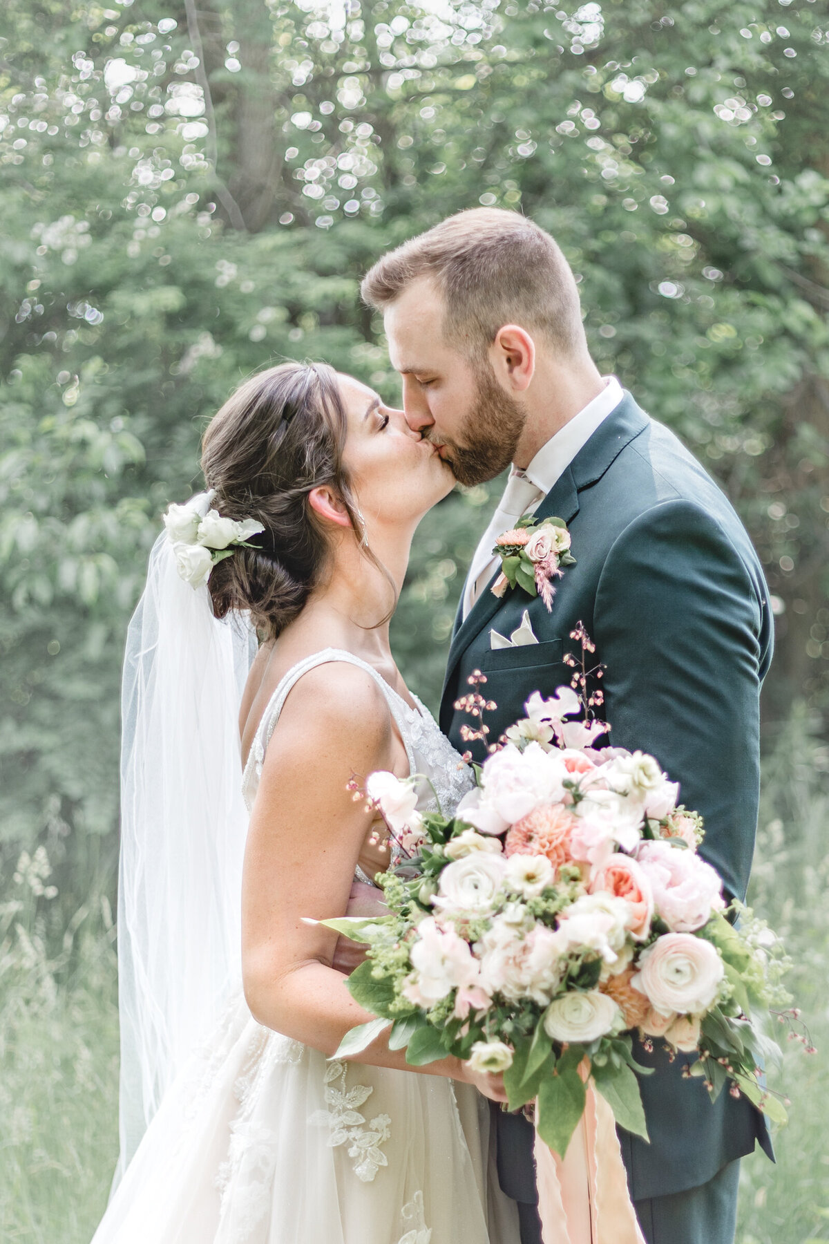 A bride and groom kiss at their garden wedding