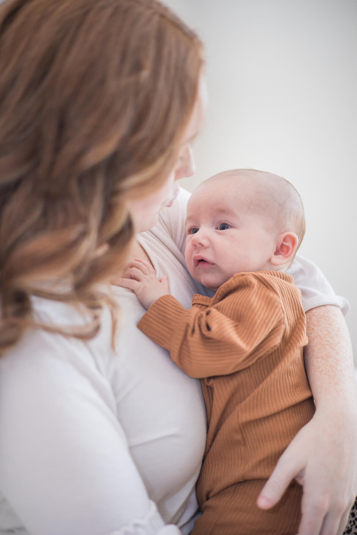 infant son looking at his mom concerned