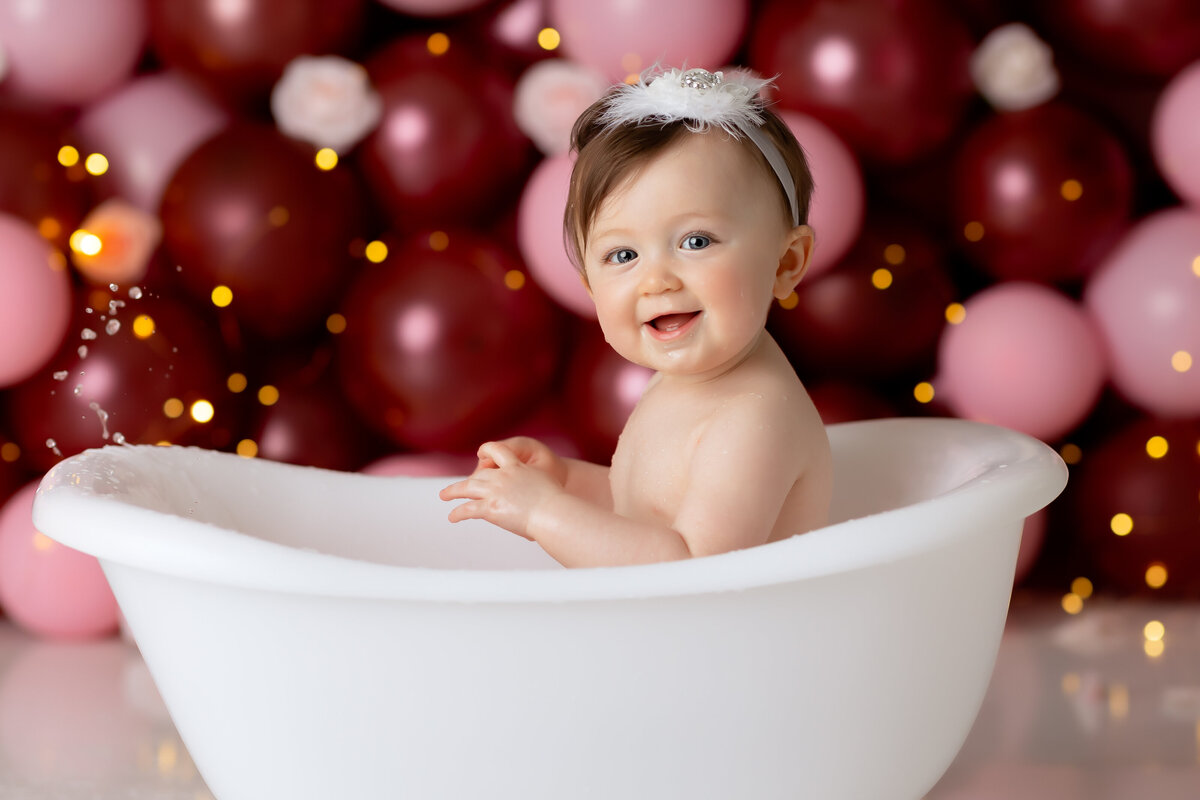 One year old Tampa baby enjoying a personalized luxury cake smash session with playful decorations