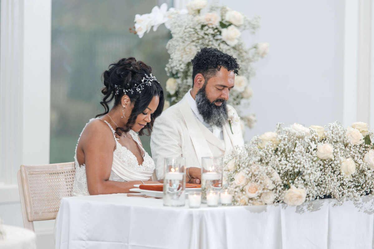 A candid moment of the newlyweds sharing a meal and laughter at their reception.