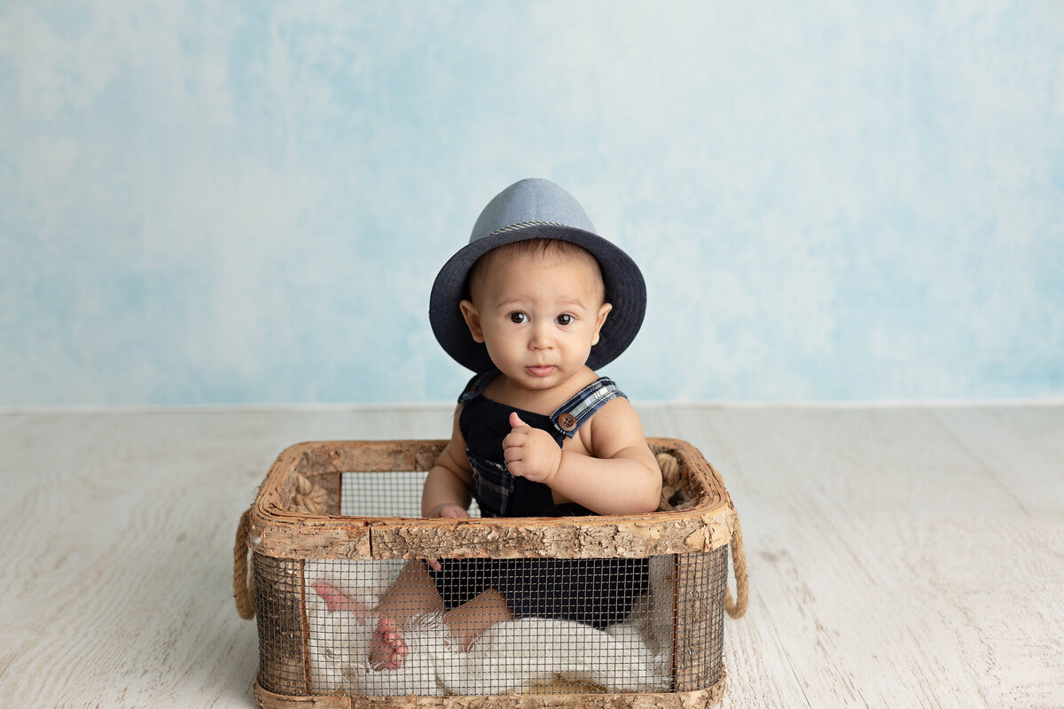 columbus-ohio-baby-boy-sitting-in-basket-with-cute-romper-and-hat
